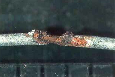 Corrosion of isolated steel fiber at an intersection with a crack